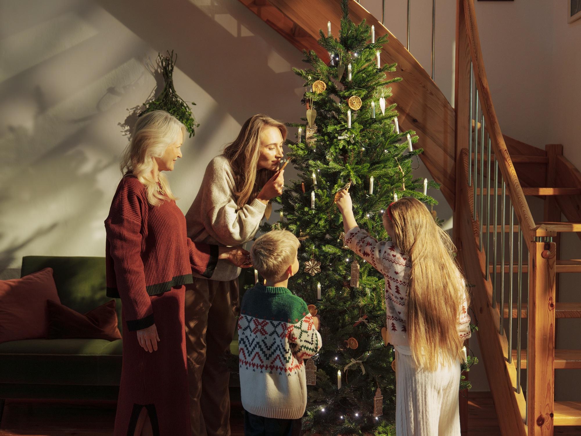 Rodzina wspólnie dekoruje choinkę Fairytrees FT33 na święta