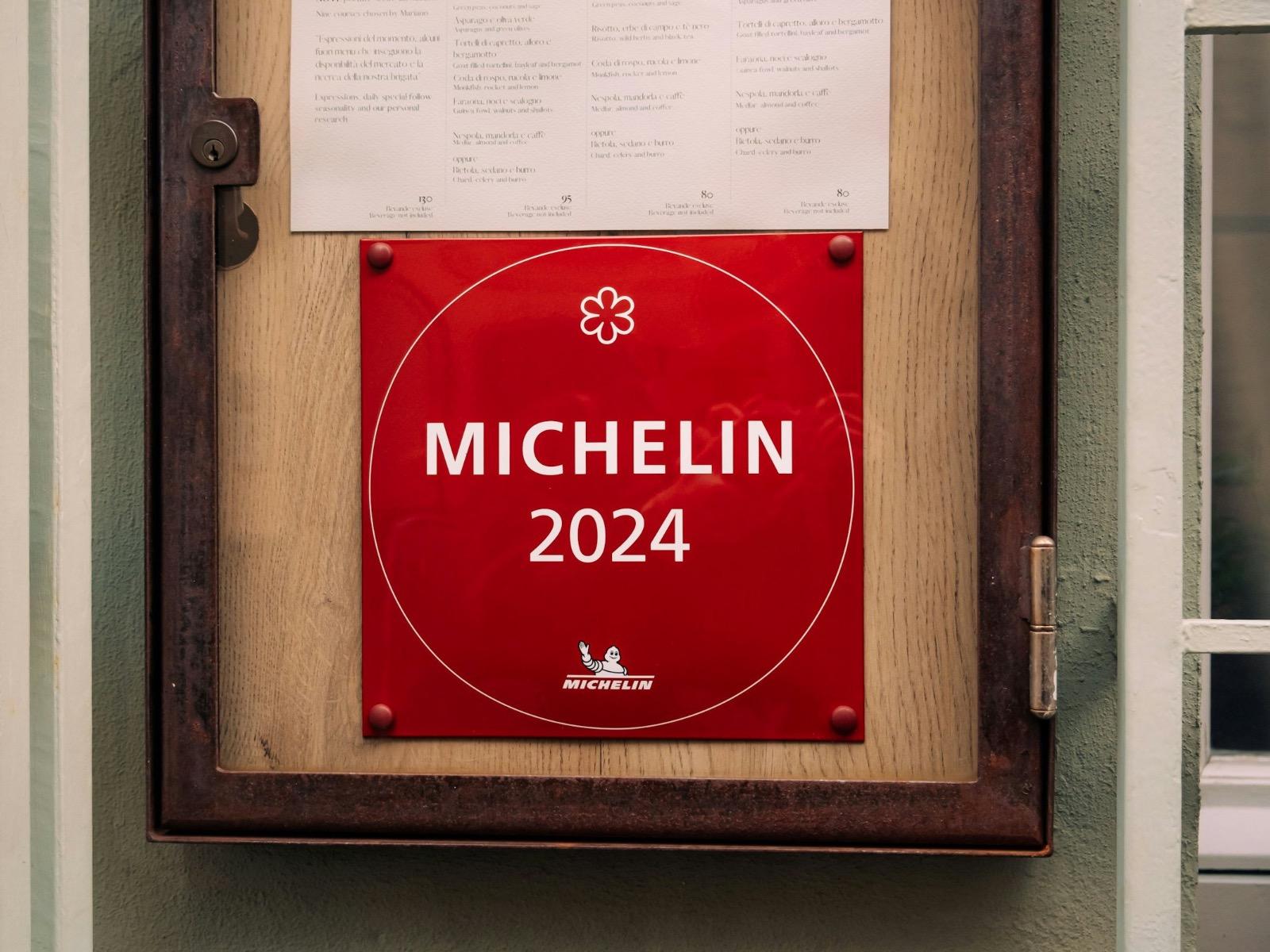 Czerwona tabliczka Michelin 2024 umieszczona w witrynie restauracji w Rimini we Włoszech.